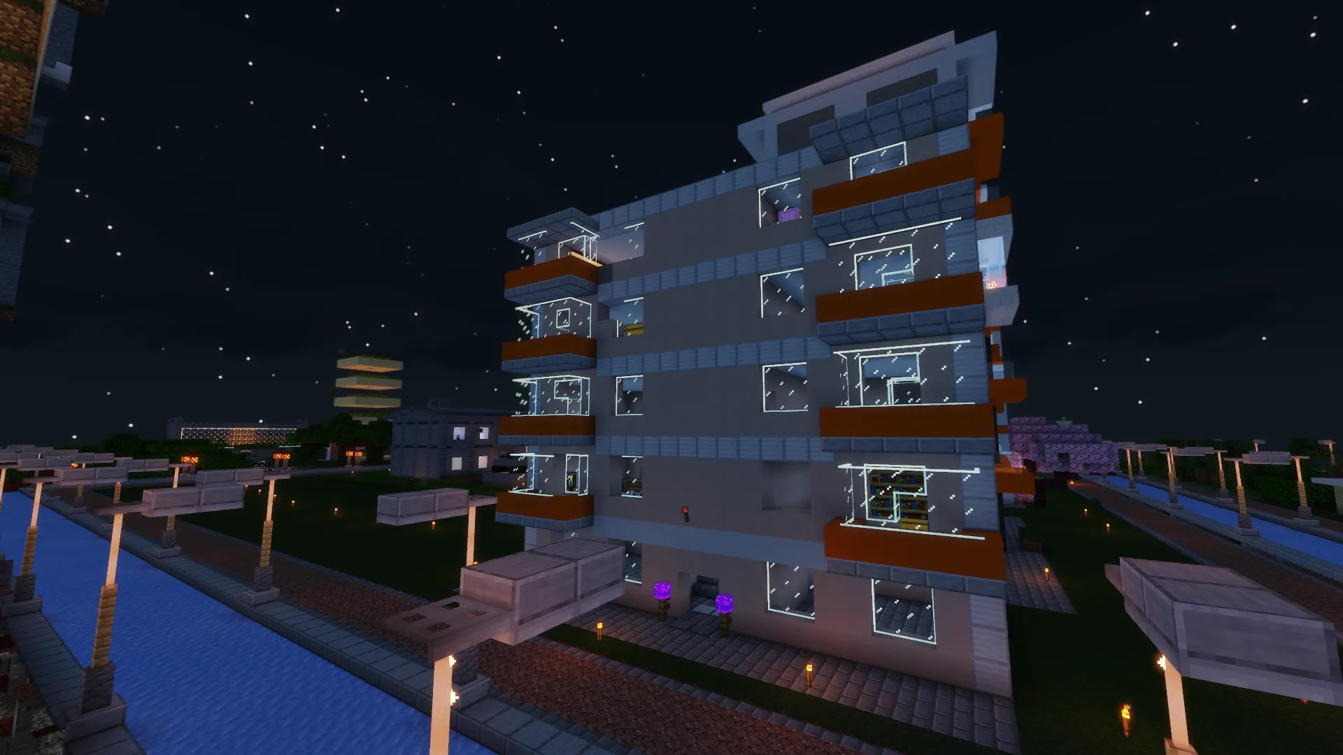 Многоэтажка в Minecraft с обставленными квартирами и балконами, ночной вид