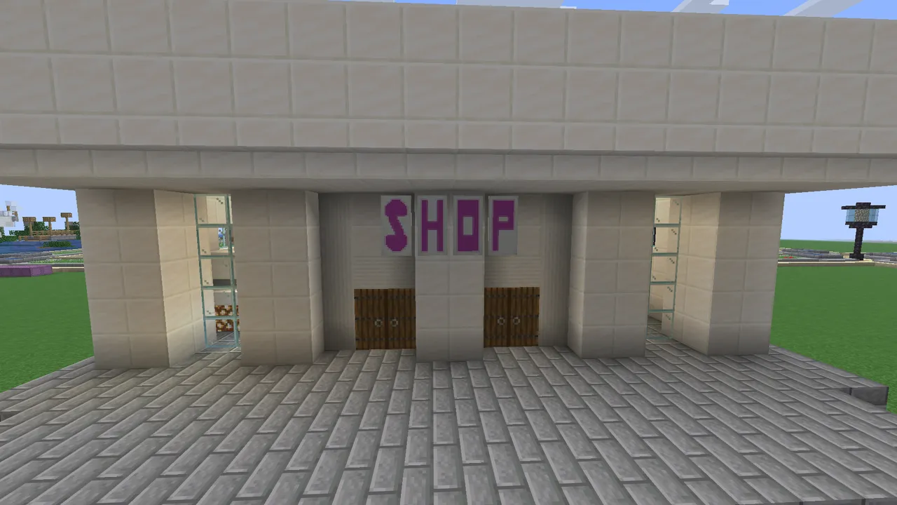 Надпись SHOP из четырёх флагов на белой кварцевой стене в Minecraft