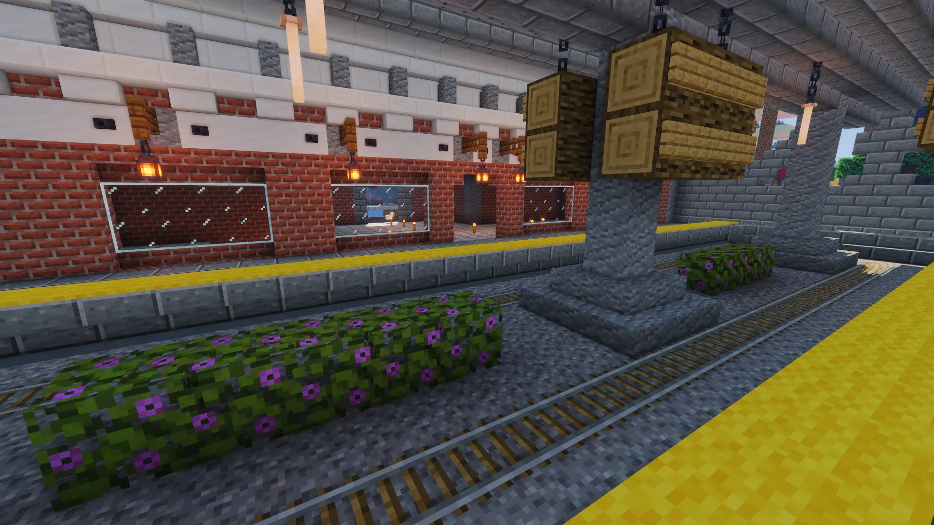 Платформа вокзала в Minecraft с кирпичной стеной, подвесными указателями и клумбами